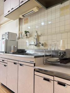 a kitchen with a sink and a counter top at Kumamoto Serviced Apartment Sakura Mee 桜美 in Kumamoto