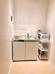 Una pequeña cocina con fregadero y microondas. en Résidence Rachel Shape Mons, en Mons