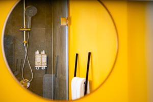 um espelho que reflecte um chuveiro na casa de banho em Glória Suites Hotel em Lisboa