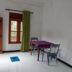 a dining room with a table and chairs and a window at Doubleson villa in Ahangama