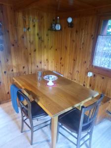 - une table et des chaises en bois dans une chambre dotée de murs en bois dans l'établissement Chalet mayou, à Châtillon-sur-Cluses