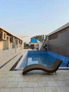 una piscina con una panchina accanto a un edificio di Duggar Haveli Hotel & Restaurant a Jammu