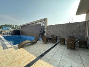 un patio con tavolo e sedie accanto alla piscina di Duggar Haveli Hotel & Restaurant a Jammu