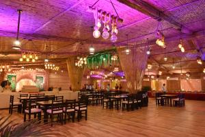 ein Esszimmer mit Tischen und Stühlen und violetter Beleuchtung in der Unterkunft Duggar Haveli Hotel & Restaurant in Jammu