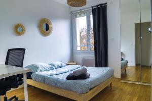 a bedroom with a bed and a desk and a window at Le TRIANGLE D OR B in Vaires-sur-Marne