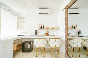 a kitchen with a counter and chairs in a room at Mare 1BR Romantic Villa, 5 Min to Thomas Beach in Uluwatu