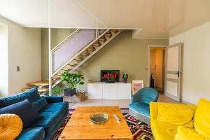 a living room with a blue couch and a table at Appartement d'exception - proche de la mer in Saint-Brieuc