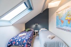 two beds in a room with a dog sleeping on the floor at Appartement d'exception - proche de la mer in Saint-Brieuc