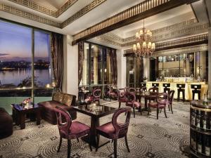 - un salon avec des tables, des chaises et un bar dans l'établissement Fairmont Nile City, au Caire