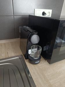 a coffee maker with a glass inside of a microwave at Garsoniéra za Bezručem in Slezská Ostrava