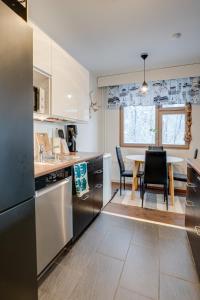 a kitchen with stainless steel appliances and a table with chairs at Matti's Charming Studio in Rovaniemi +19 photos