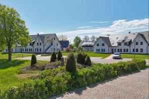 a row of houses with a car parked in a driveway at Strandresort Rex Rugia Ferienwohnung 14-6 mit Sauna- und Schwimmbadnutzung im AHOI Sellin in Lobbe