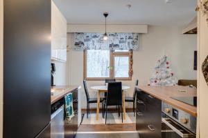a kitchen with a table and a christmas tree at Matti's Charming Studio in Rovaniemi