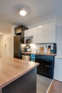 a kitchen with white cabinets and a wooden counter top at Matti's Charming Studio in Rovaniemi