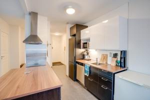 a kitchen with white cabinets and a wooden counter top at Matti's Charming Studio in Rovaniemi