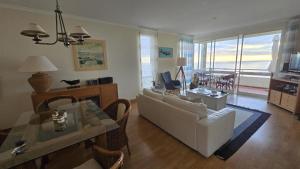 a living room with a white couch and a table at Apartamento do Sol in Arco da Calheta