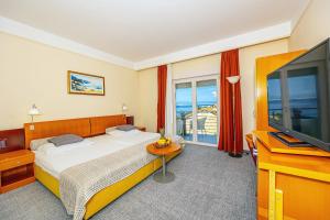 セルツェにあるHotel Marinaのベッドと薄型テレビのある寝室