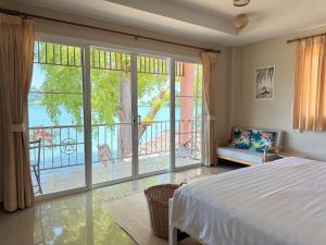a bedroom with a bed and a large window at Secret Place in Panwa Beach