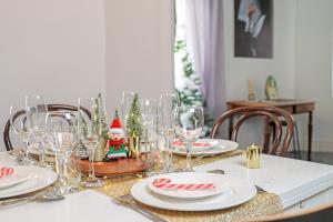 une table de salle à manger avec des verres et des décorations de Noël dans l'établissement Les Gîtes de Laure - L'Or Vert, Appartement avec Vue sur le Château, Parking Privé, Climatisation, Netflix, à 160 m de la Cité Médiévale, à Carcassonne 23 autres photos