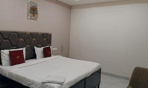 Un dormitorio con una cama grande con almohadas rojas. en FabHotel Kalka Residency, en Nueva Delhi