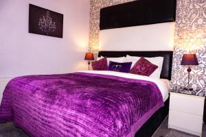 a purple bed with purple sheets in a bedroom at Kenley Hotel in Blackpool
