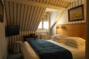 a hotel room with a bed and a television at Saint James in Trouville-sur-Mer