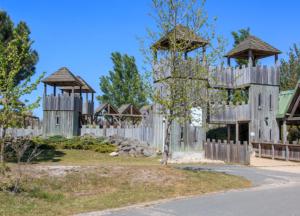 Le petit chalet du Lac Hourtin في هورتين: حديقة بها سياج خشبي وشرفة مراقبة