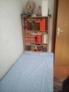 una cama en una habitación con una estantería en little room, en Konjic