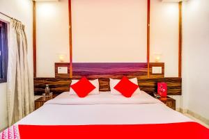 a bedroom with a large bed with red pillows at Collection O Panchratna in Panvel