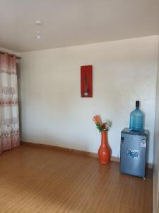 a room with a vase and a bottle on the floor at Jay homes in Kakamega