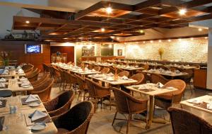 uma sala de jantar cheia de mesas e cadeiras em Maceió Mar Hotel em Maceió
