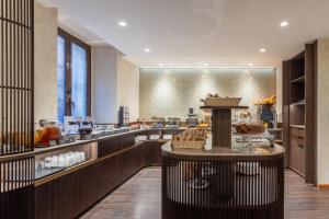 Una panadería con exposición de pasteles y comida. en Hotel Raffaello - Sure Hotel Collection by Best Western, en Roma