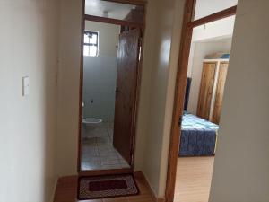 a hallway with a mirror in a room with a bed at Jay homes in Kakamega