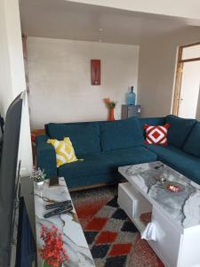 a living room with a blue couch and a table at Jay homes in Kakamega