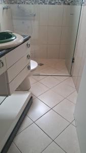 Itapema beira mar في ايتابيما: حمام مع دش ومغسلة ومرحاض