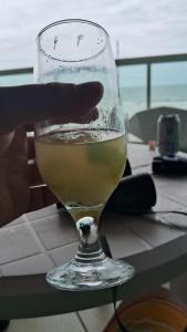 Itapema beira mar في ايتابيما: كوب من النبيذ على طاولة +12 صورة