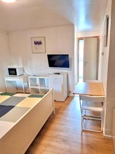 Habitación con cama, escritorio y mesa. en Résidence Rachel Shape Mons, en Mons