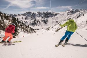 dos personas están esquiando por una montaña cubierta de nieve en Jagdhaus, en Mayrhofen
