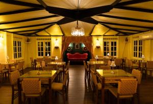 ein Restaurant mit Tischen und Stühlen und einem Kronleuchter in der Unterkunft El Oasis Hotel in Aguada