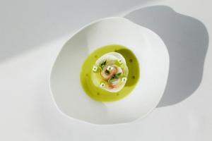 ein weißer Teller mit grüner Soße und Essen darauf in der Unterkunft MYRIAD by SANA Hotels in Lissabon