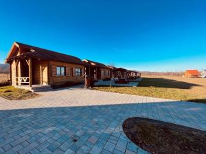 a house with a brick driveway in front of it at Székelyföld Fogadó in Borzont