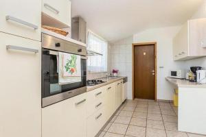 a kitchen with white cabinets and a stove top oven at Olive Garden Krk in Brzac +25 photos