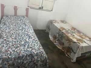 Belo MonteにあるRecanto da florの掛け布団が敷かれたベッドのある寝室