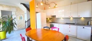 a kitchen with a wooden table and pink chairs at Maison 6 personnes Angouleme in Angoulême