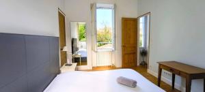 a bedroom with a bed and a desk and a window at Maison 6 personnes Angouleme in Angoulême +12 photos