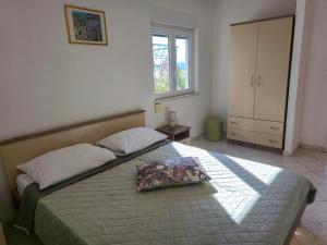 a bedroom with a bed with a pillow on it at Apartments Giran in Lokva Rogoznica +34 photos