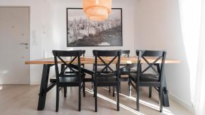 a dining room table with black chairs and a painting at San Torcuato VIII by Toledo AP in Toledo