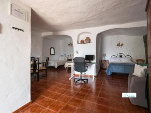 a bedroom with a bed and a desk in a room at Living Artenara - CAVE HOUSE & TERRACE Adults Only in Artenara