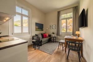 Teinach Suites - Villa Wilhelmshöhe في باد تايناخ-تسافلشتاين: غرفة معيشة بها أريكة وطاولة