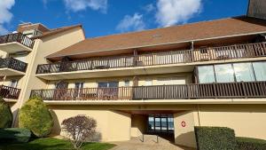 a large apartment building with balconies on it at Le Panorama, confortable appartement - accès direct à la plage in Bernières-sur-Mer